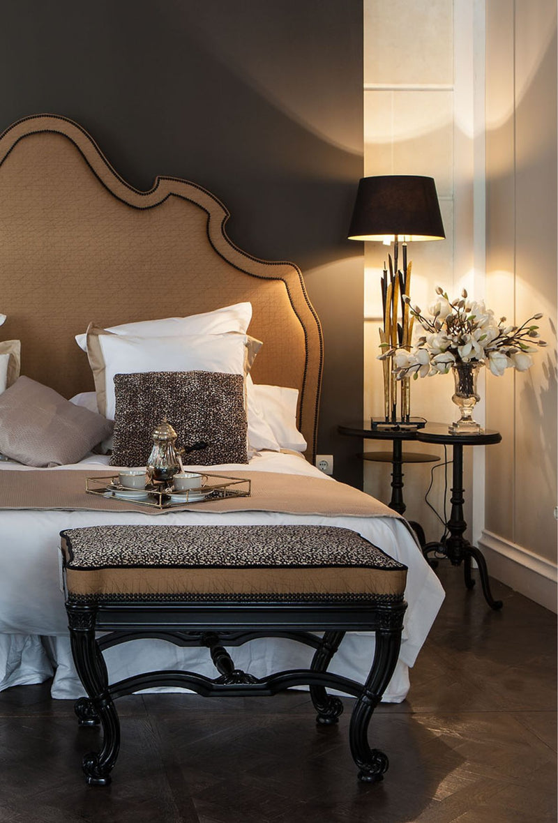 Chambre à coucher de château avec un lit, tête de lit et un banc