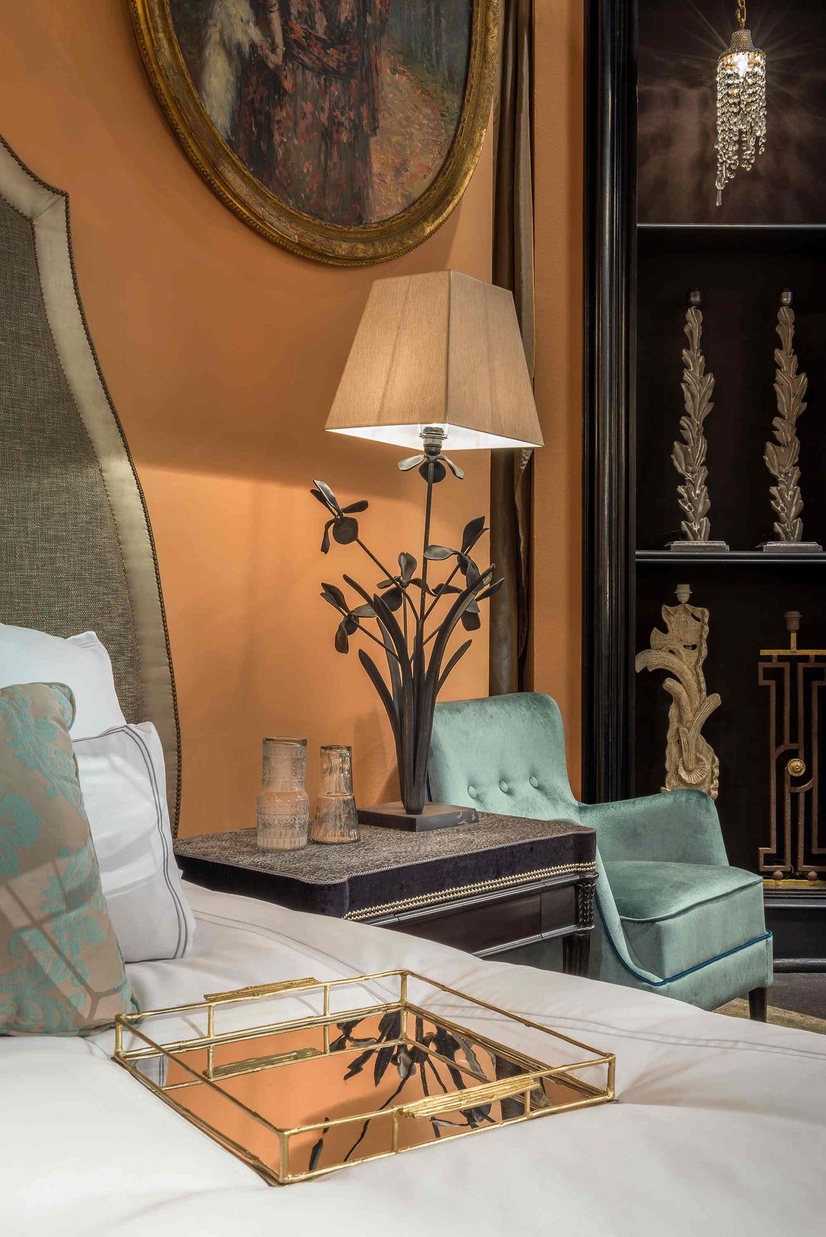 Chambre de château avec un lit, un chevet et une lampe