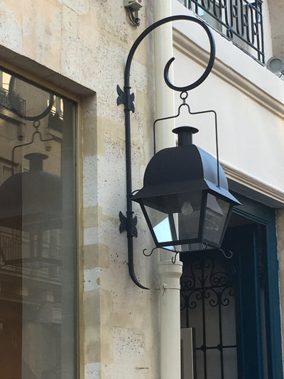 Lanterne à suspendre Nîmes patine noire accrochée sur le mur d'un hôtel